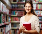 Portrait of clever student with book in college library